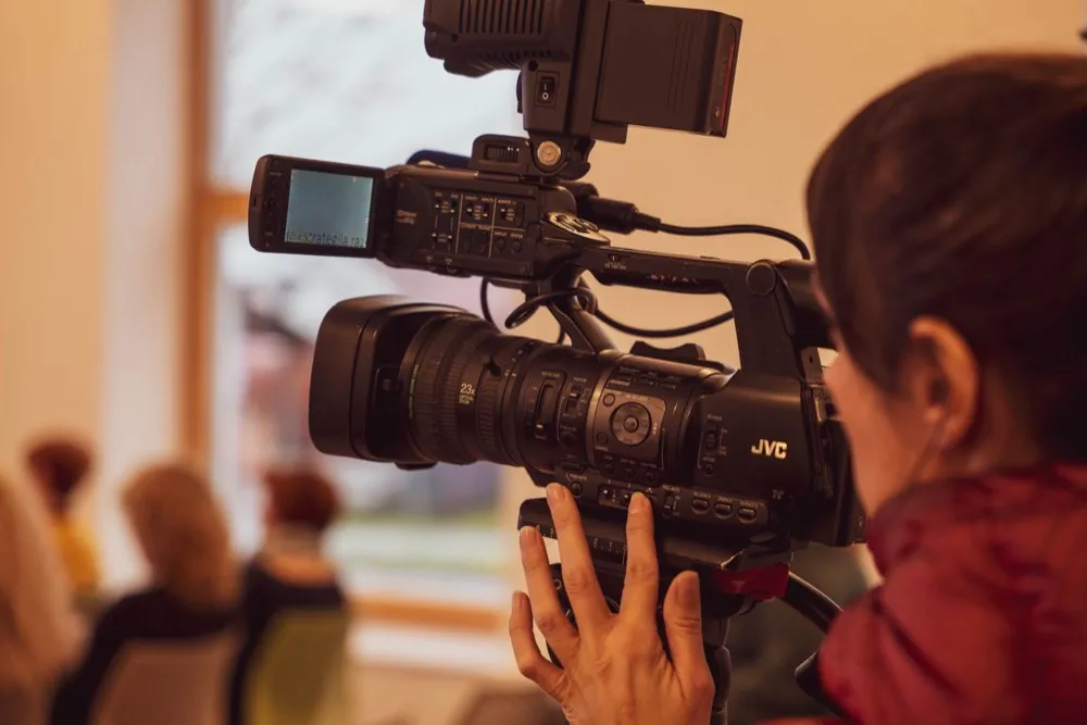 A camera operator filming an interview.